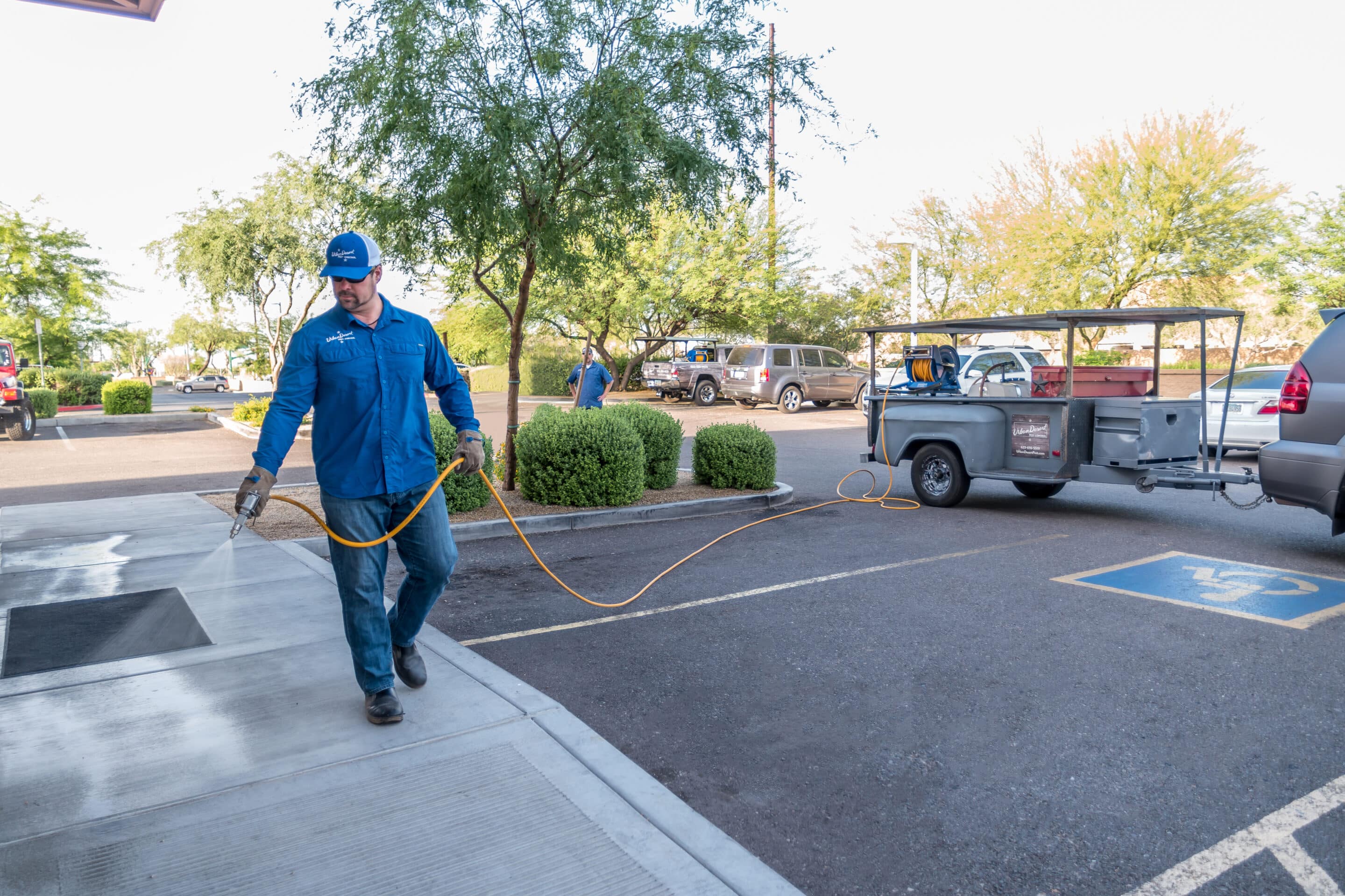 A team member of Urban Desert Pest Control's team provides pest control company services using sprayer.